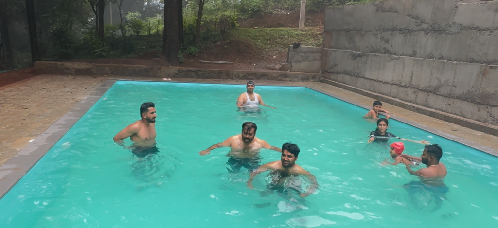 Swimming pool at Wild Fog Resort surrounded by lush greenery in Sakleshpur.